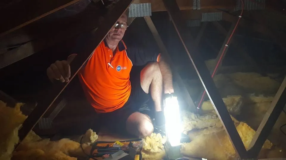 Pete photo from the roof space at Club Crocodile Airlie Beach. Working with a torch among timber rafters and fibreglass insulation.