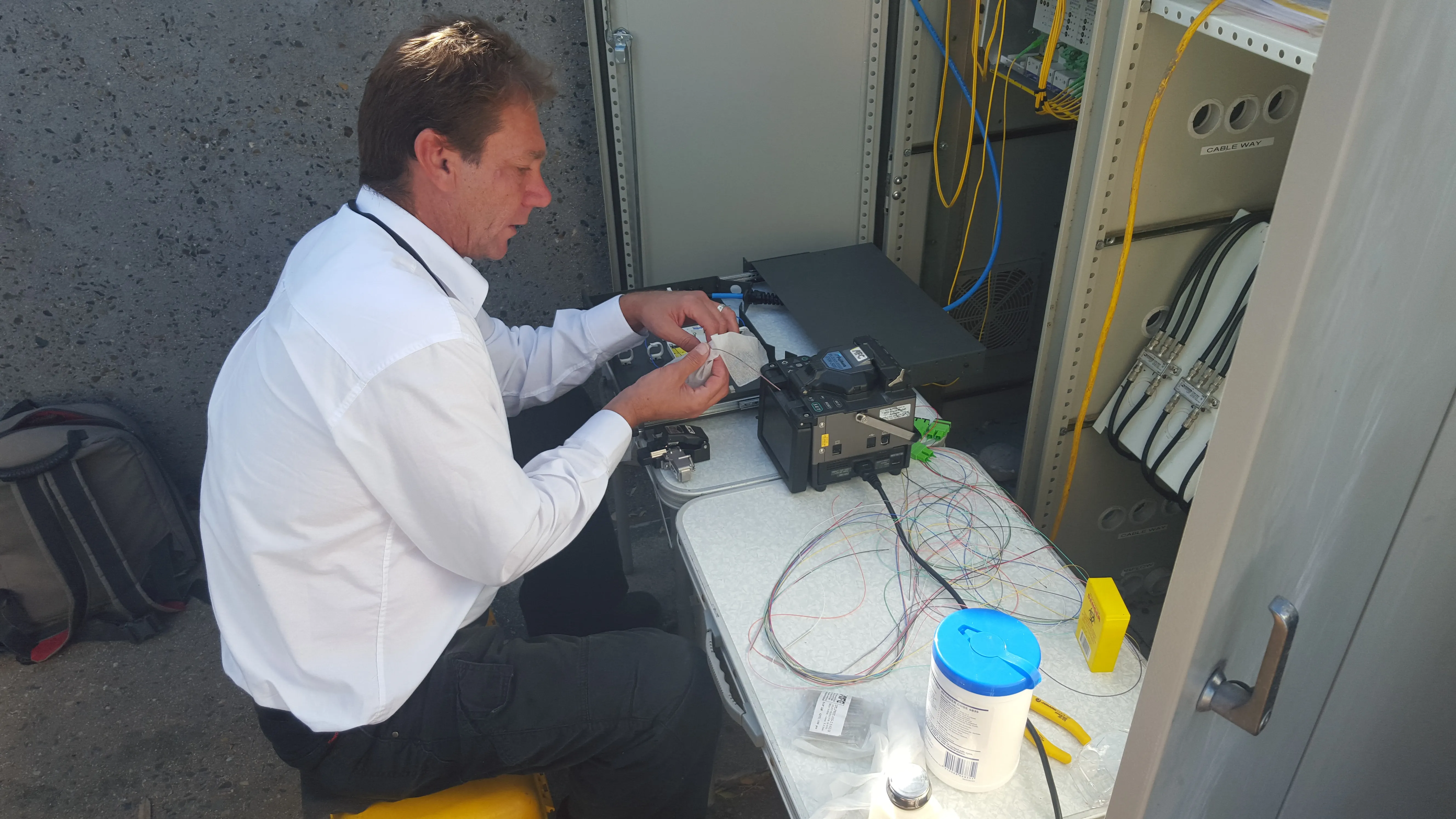 Fusion splicing 24-core fibre optic terminations at a Whitsunday Regional Council street cabinet in Proserpine, Queensland