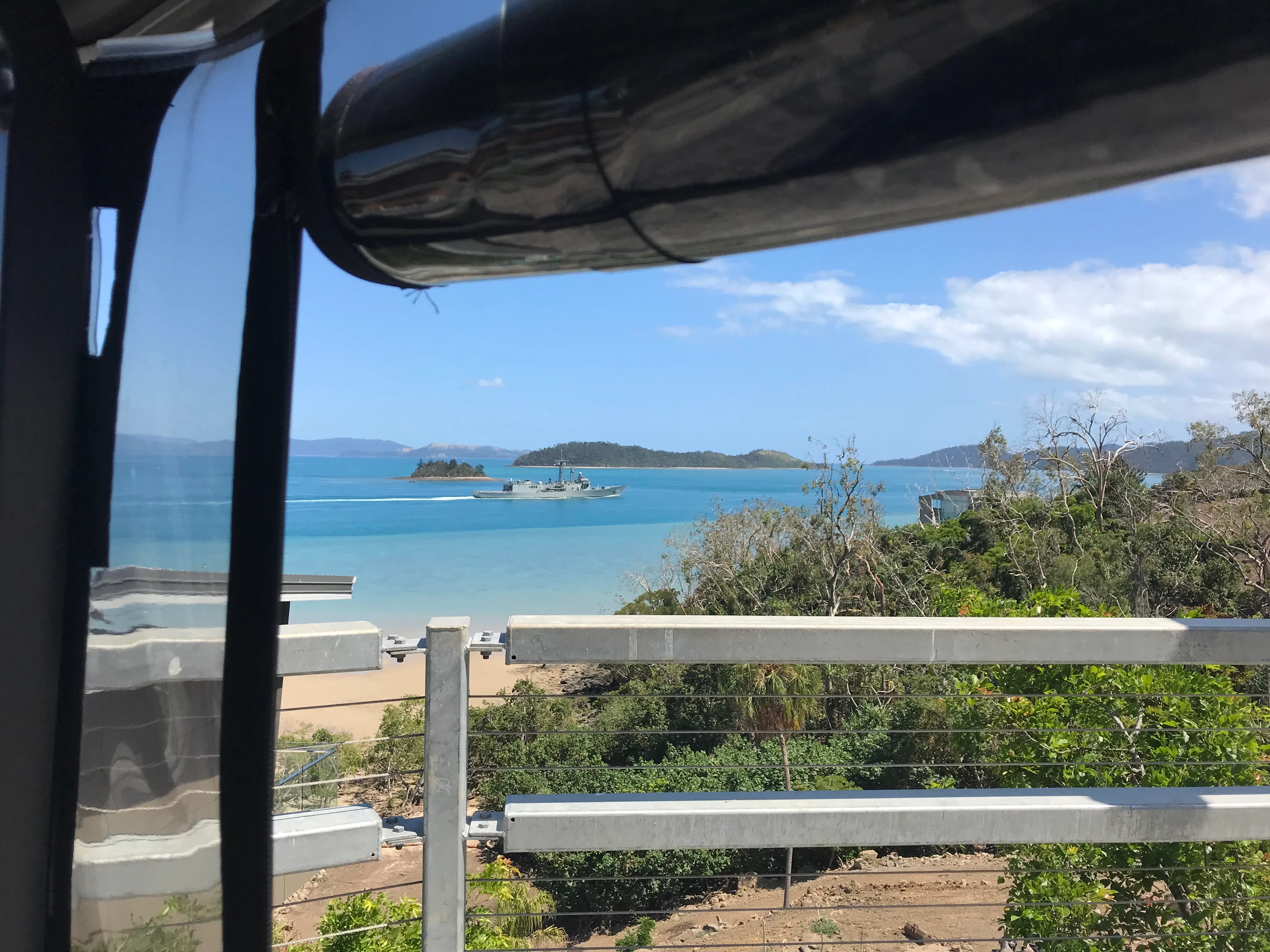 Suspended road across Hidden Cove — with a navy patrol thrown in for good measure. The fully elevated roads had no easements at all, which ruled out underground services from the start and set up the whole suspended-cable challenge. The HMAS turning up was a bonus.